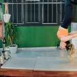 Woman practicing reformer pilates exercise in a modern fitness studio